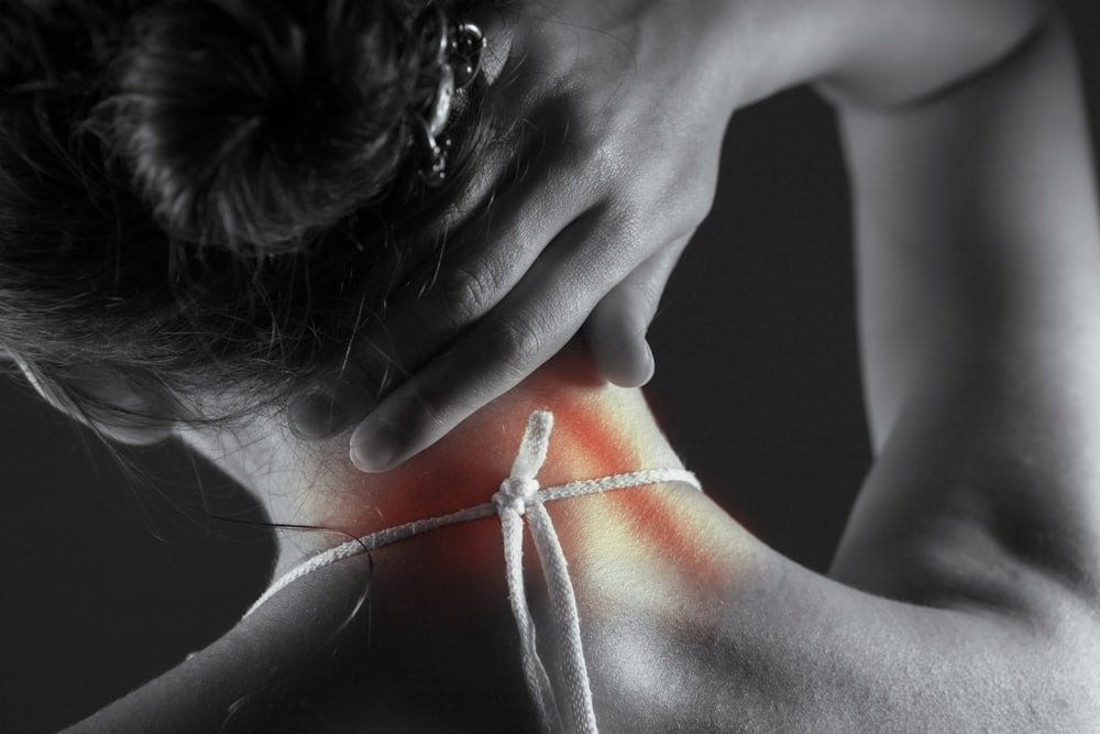 Person with neck and back pain from working hunched over a low laptop